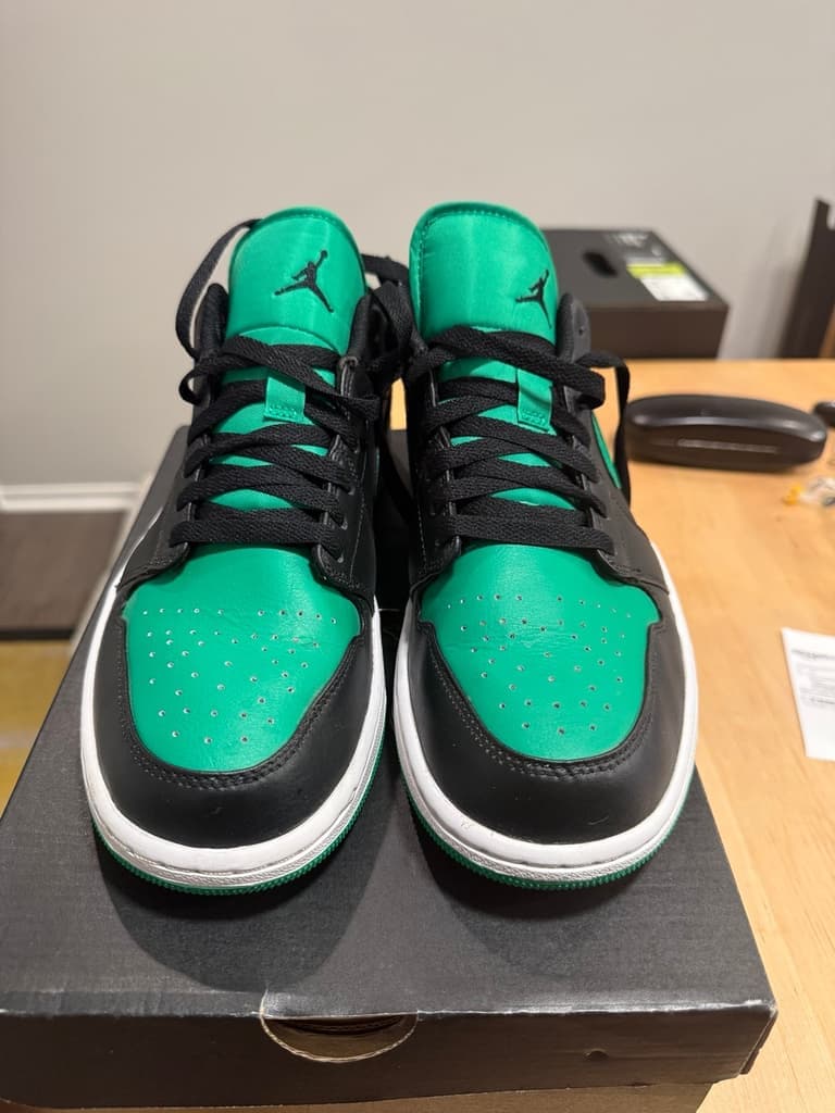 Front view of the black and green Air Jordan 1 Low sneakers